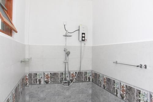una doccia in bagno con piastrelle sul muro di Panora Garden a Mirissa