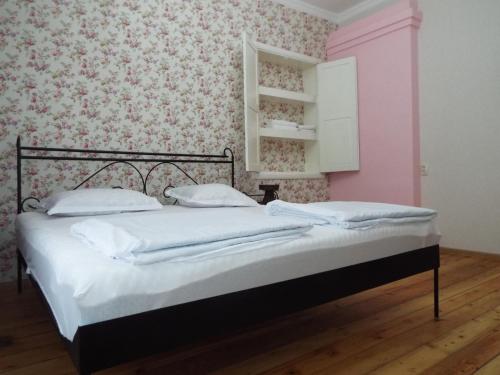 a bed in a room with a pink wall at Nino's House in Tsinandali
