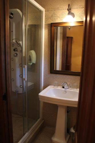 a bathroom with a sink and a shower with a mirror at Posada San Martin in Cuenca