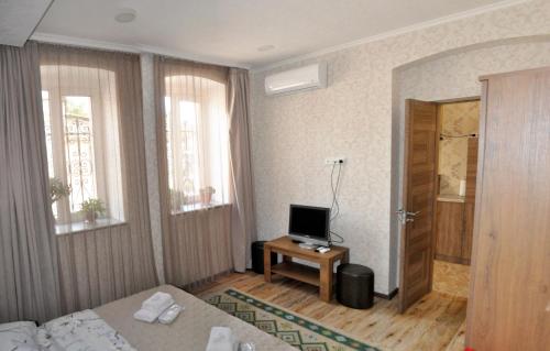 a room with a bed and a television on a table at Apartments on Akhalubani St 2 in Tbilisi City