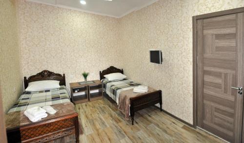 two twin beds in a room with a door at Apartments on Akhalubani St 2 in Tbilisi City