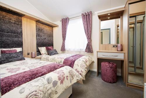 En eller flere senger på et rom på New Forest Lodges Bashley Park