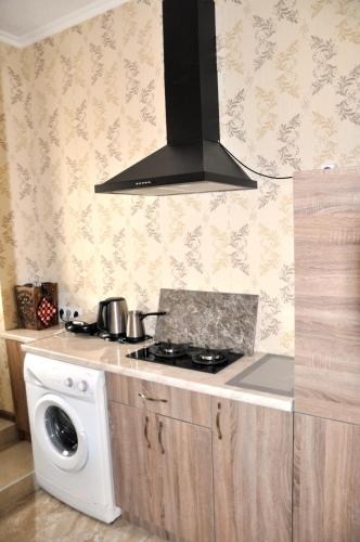 a kitchen with a stove and a washing machine at Apartments on Akhalubani St 2 in Tbilisi City