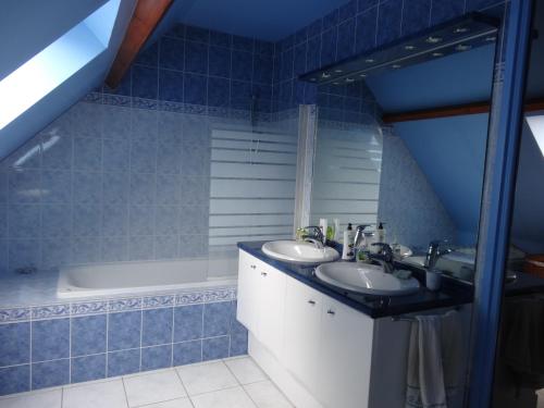 uma casa de banho em azulejos azuis com 2 lavatórios e uma banheira em 3 Chambres-Disneyland Paris em Saint-Thibault-des-Vignes