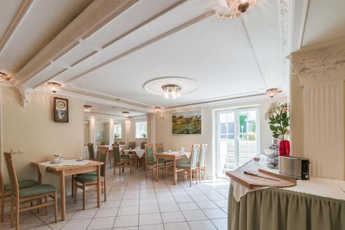 ein Restaurant mit Tischen und Stühlen in einem Zimmer in der Unterkunft Hotel Villa am Waldschlösschen in Dresden