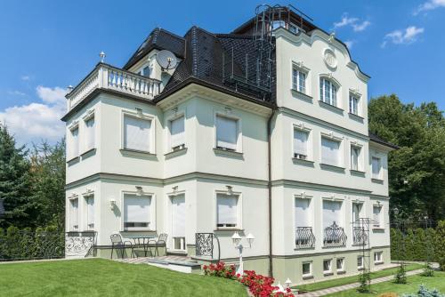 a large white building with a black roof at Hotel Villa am Waldschlösschen in Dresden