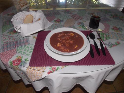 a table with a bowl of chili and a plate of food at Hotel Casa Duranta in Cobán