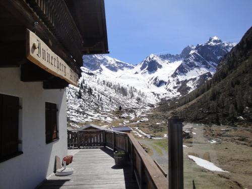 a balcony of a building with a view of a snow covered mountain at Ferienwohnungen Vier Jahreszeiten in Längenfeld