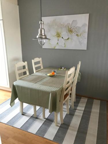 a dining room table with a green tablecloth and chairs at City apartment in Rovaniemi