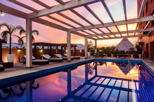 ein Pool mit einer Pergola und ein Resort in der Unterkunft Barcelo Guadalajara in Guadalajara