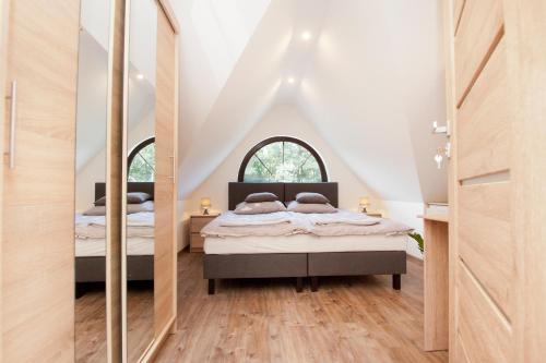 a bedroom with two beds and a mirror at Agrodomki z bali Konradow in Konradów