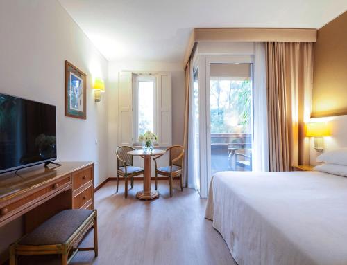
a hotel room with a large bed and a television at Dom Pedro Marina in Vilamoura
