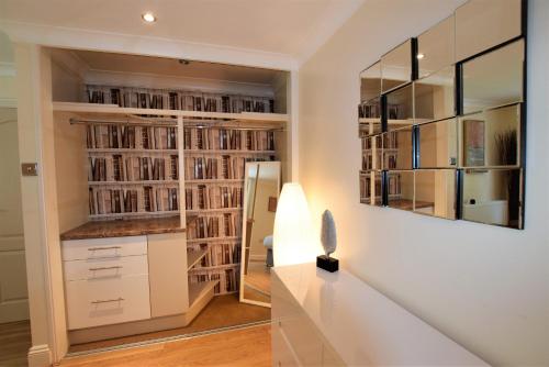 a home library with white cabinets and a mirror at Meridian Way - 3 Bed Apartment - Sleeps 7 in Bristol