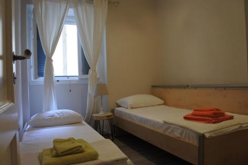 2 camas en una habitación pequeña con ventana en Kondessa Corfu Old Town Apartment, en Corfú