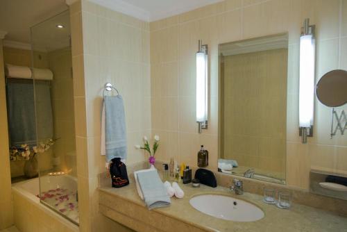 a bathroom with a sink and a mirror and a tub at Taba Sands Hotel & Casino - Adult Only in Taba