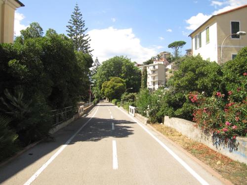 uma estrada vazia numa cidade com árvores e arbustos em San Michele em Arma di Taggia