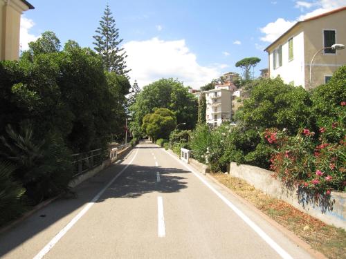 una strada vuota in una città con alberi e cespugli di San Michele ad Arma di Taggia