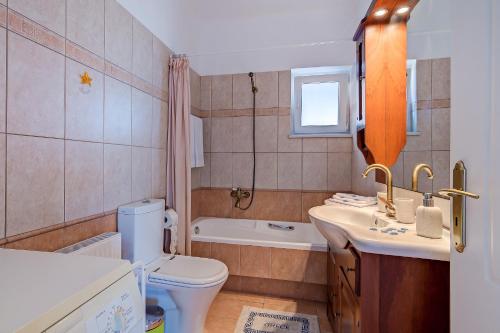Un baño con inodoro, lavabo y bañera. en Villa Vamagia BY APOKORONAS-VILLAS, en Plaka