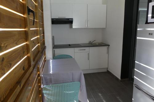 a small kitchen with a table and two chairs at Cote Plage in La Saline les Bains