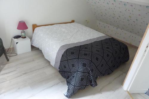 een bed met een zwart-wit dekbed in een slaapkamer bij Les Galets in Dieppe