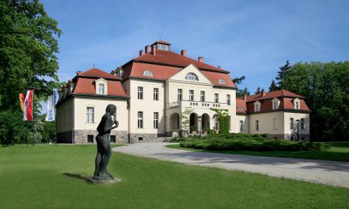 a statue in front of a large house at Schloss und Gut Liebenberg in Liebenberg