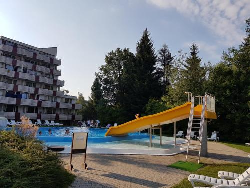 a swimming pool with a yellow slide in a resort at Appartements im Predigtstuhl Resort in Sankt Englmar