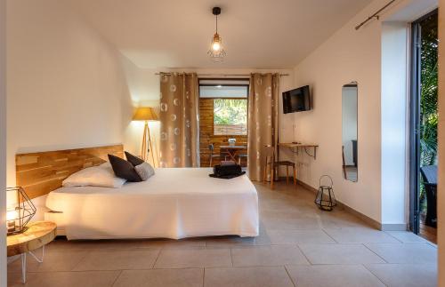 a bedroom with a large white bed in a room at Cote Plage in La Saline les Bains
