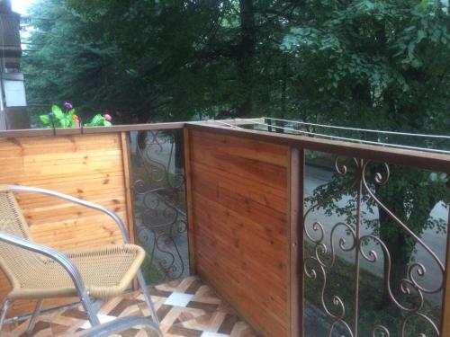 a balcony with a wooden fence and chairs on it at DILIJAN Apartment in Dilijan