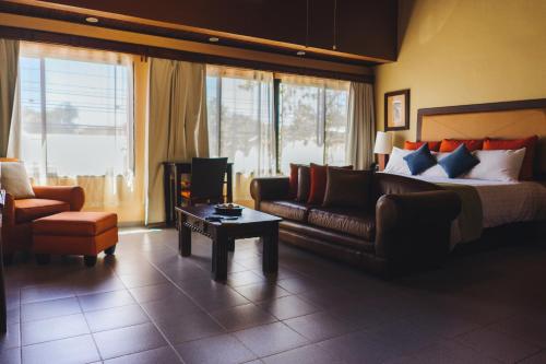 una camera d'albergo con letto, divano e sedia di Humuya Inn a Tegucigalpa