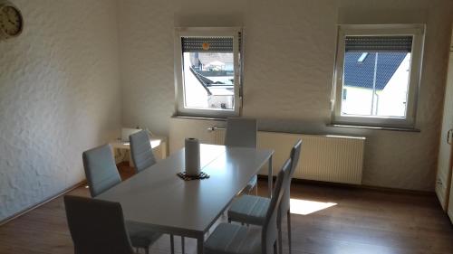 a dining room with a table and chairs and two windows at Gaststätte Molitor in Saarlouis