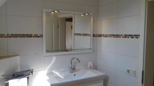 a white bathroom with a sink and a mirror at Gaststätte Molitor in Saarlouis