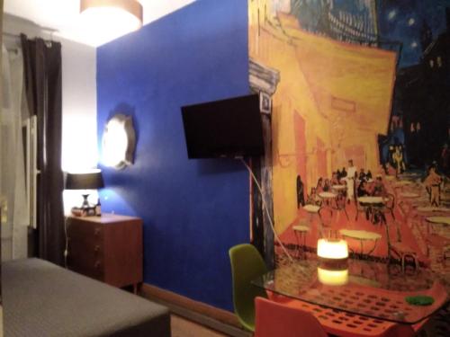トルンにあるBeautiful Apartmentの青い壁の客室で、テーブル、テレビが備わります。