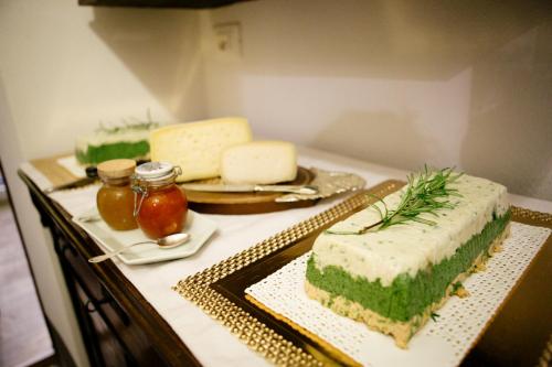 a table with several different types of cheeses on it at Domus Socolatae Residenza d'Epoca Charming B&B - Adults Only in Follonica