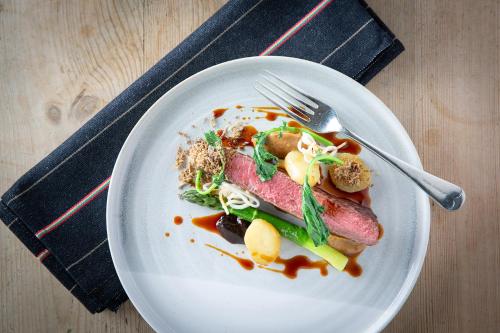 a plate of food with meat and vegetables on a table at The Black Bull Inn in Sedbergh