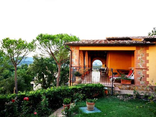 a small house with a balcony and a patio at La Biocca in Poggio Murella