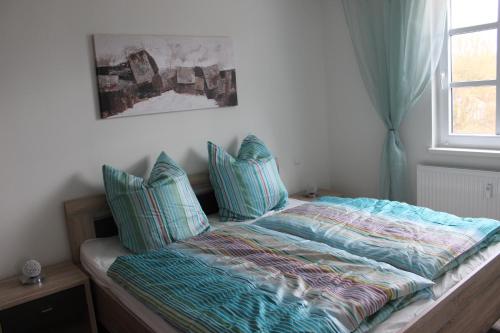 ハイリゲンダムにあるFerienwohnung Atlantisのベッドルーム1室(青い枕のベッド1台、窓付)