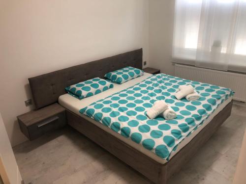 1 dormitorio con 2 camas, sábanas y almohadas azules y blancas en Luxusní apartmán přímo v centru u hotelu Thermal, en Karlovy Vary