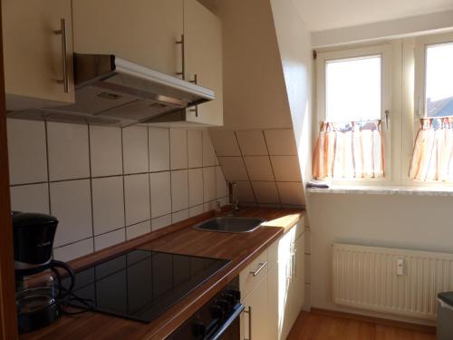 una pequeña cocina con fregadero y ventana en Ferienwohnung Liebesgrund, en Lüneburg