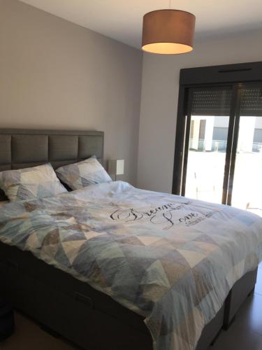 a bedroom with a bed with a quilt on it at oasis beach casa Georgio in Guardamar del Segura