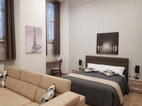 un dormitorio con una cama y un sofá en Hotel Alpi Resort, en Turín