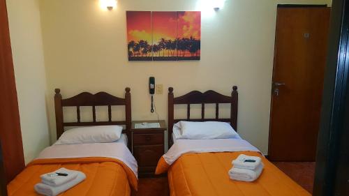 two beds sitting next to each other in a room at Hotel Paris in San Martín