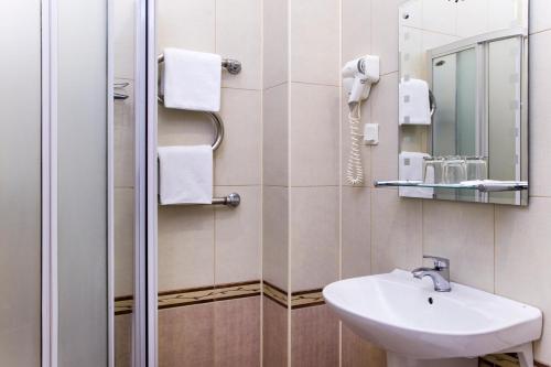 a bathroom with a sink and a mirror at Asteria Hotel in Saint Petersburg