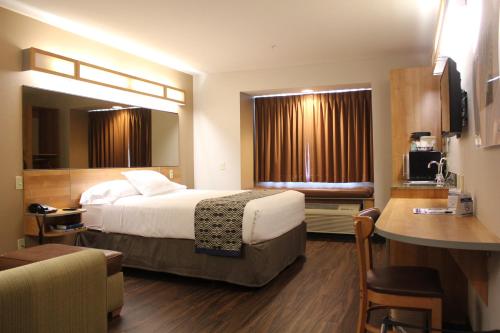 a hotel room with a bed and a desk at York Microtel Inn & Suites by Wyndham in York
