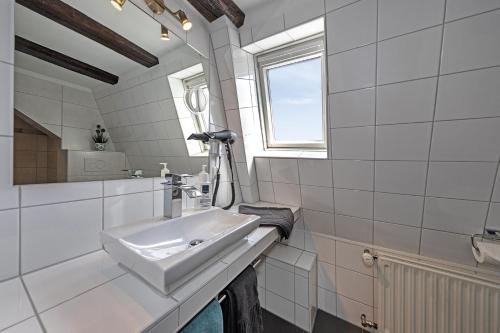a white bathroom with a sink and a mirror at Haus Mittelrhein in Rhens