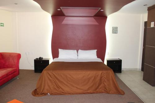 a bedroom with a bed with a red wall at Motel Septimo Eclipse in Acolman de Netzahualcóyotl