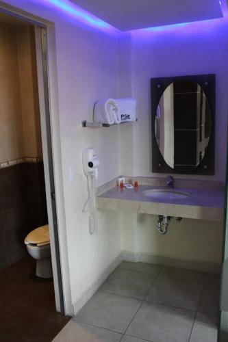 a bathroom with a sink and a mirror and a toilet at Motel Septimo Eclipse in Acolman de Netzahualcóyotl