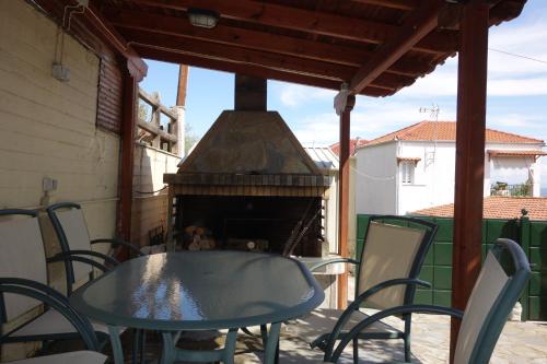 a table and chairs on a patio with a pizza oven at Beach Front House With View in Marathos
