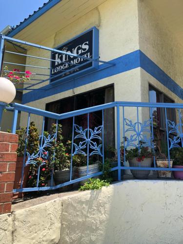 ein Geschäft mit einem blauen Geländer und Pflanzen im Fenster in der Unterkunft King Lodge Motel in Monterey Park