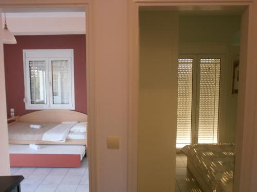 a bedroom with a bed and a room with a window at Beach Front House With View in Marathos
