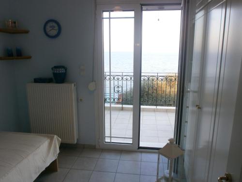 a bedroom with a door open to a balcony at Beach Front House With View in Marathos